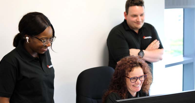 Smiling employees looking at the monitor